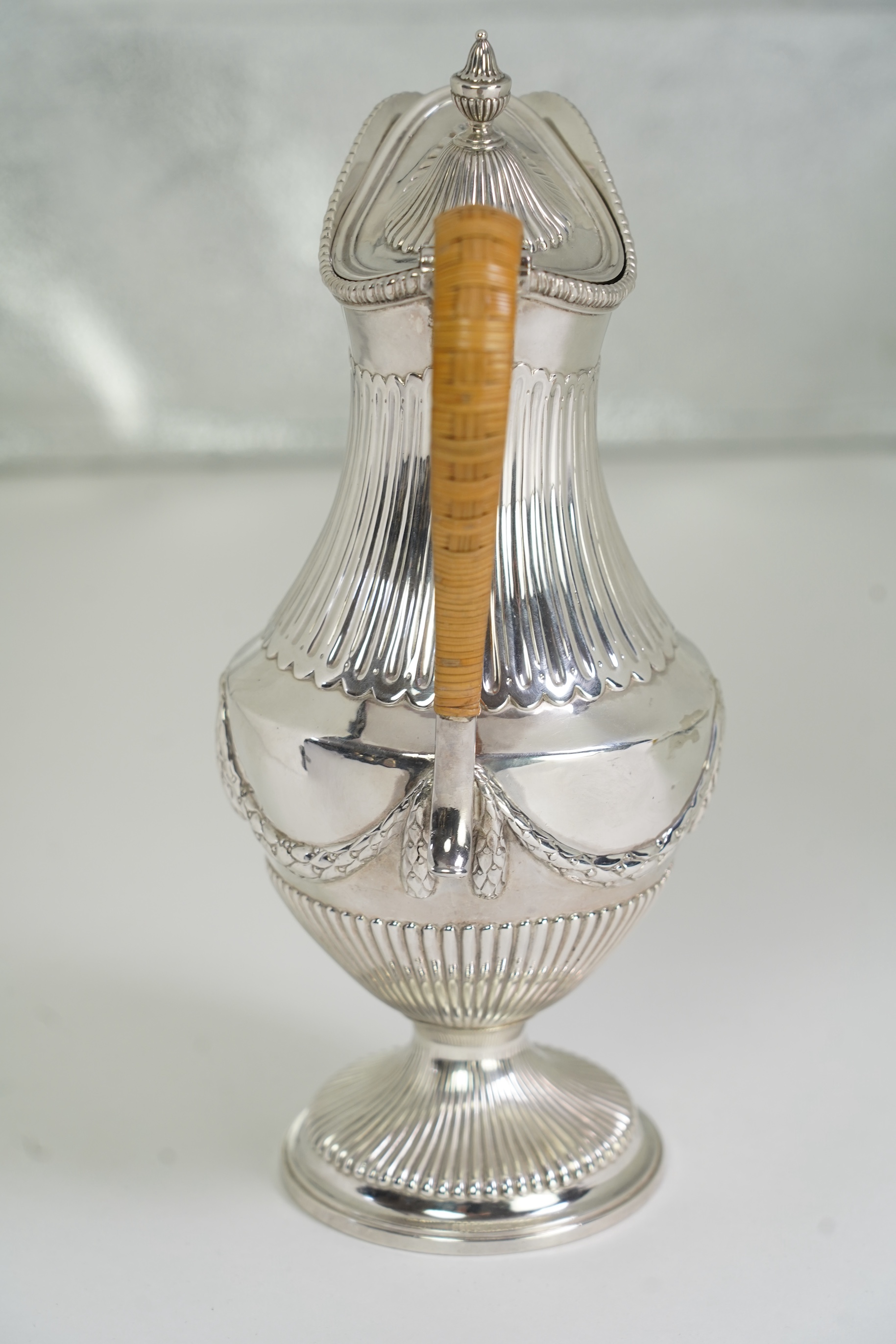 A George III neo-classical silver pedestal hot water pot, by Augustin Le Sage, engraved with the crest of The Right Reverend Robert Lowth, Bishop of London, (1710-1787)